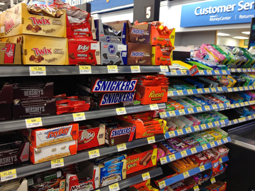 supermarket checkout display of chocolate bars, gum, and candy