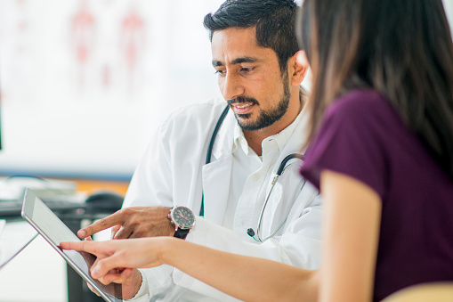woman talking with health care provider while pointing to screen